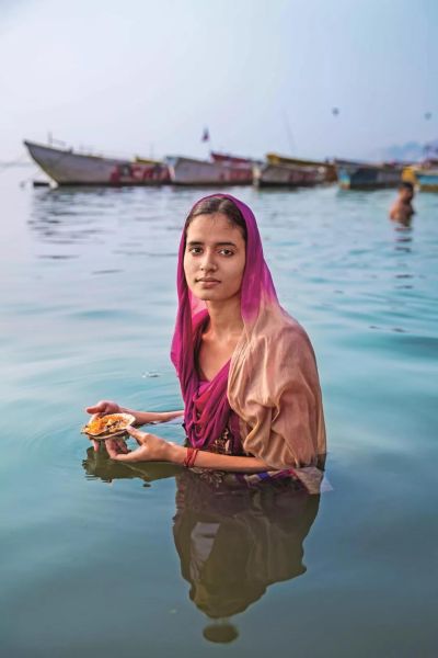 印度瓦拉纳西的恒河深处,戴着玫瑰色头纱的印度女孩正在朝圣.